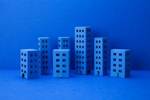 Blue paper houses on blue background. Abstract city architecture landscape